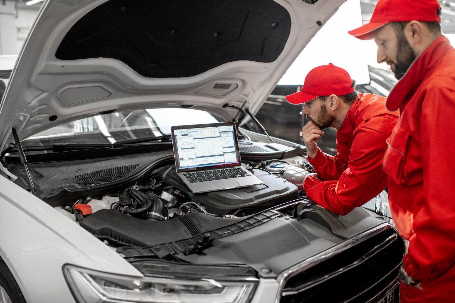 Auto Mechanics Doing Diagnostics with Laptop